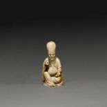 ~SUJET en ivoire, représentant le Dieu de longévité Shoulao assis tenant un rouleau dans sa main