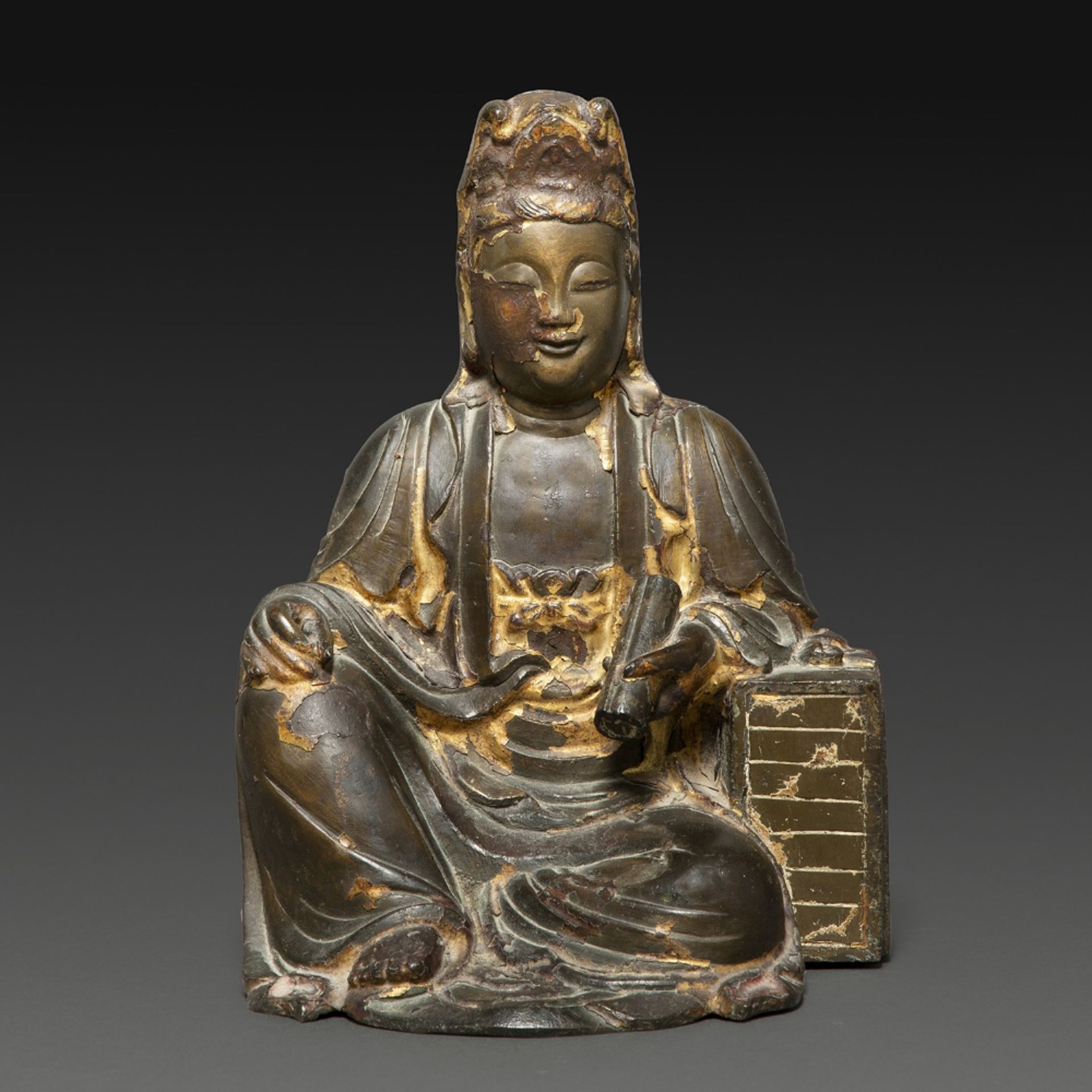 STATUETTE en bronze laqué et doré, représentant la déesse Guanyin assise en délassement, appuyée sur