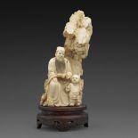 ~GROUPE en ivoire, représentant un sage lisant accompagné d'un enfant devant un rocher. Avec un
