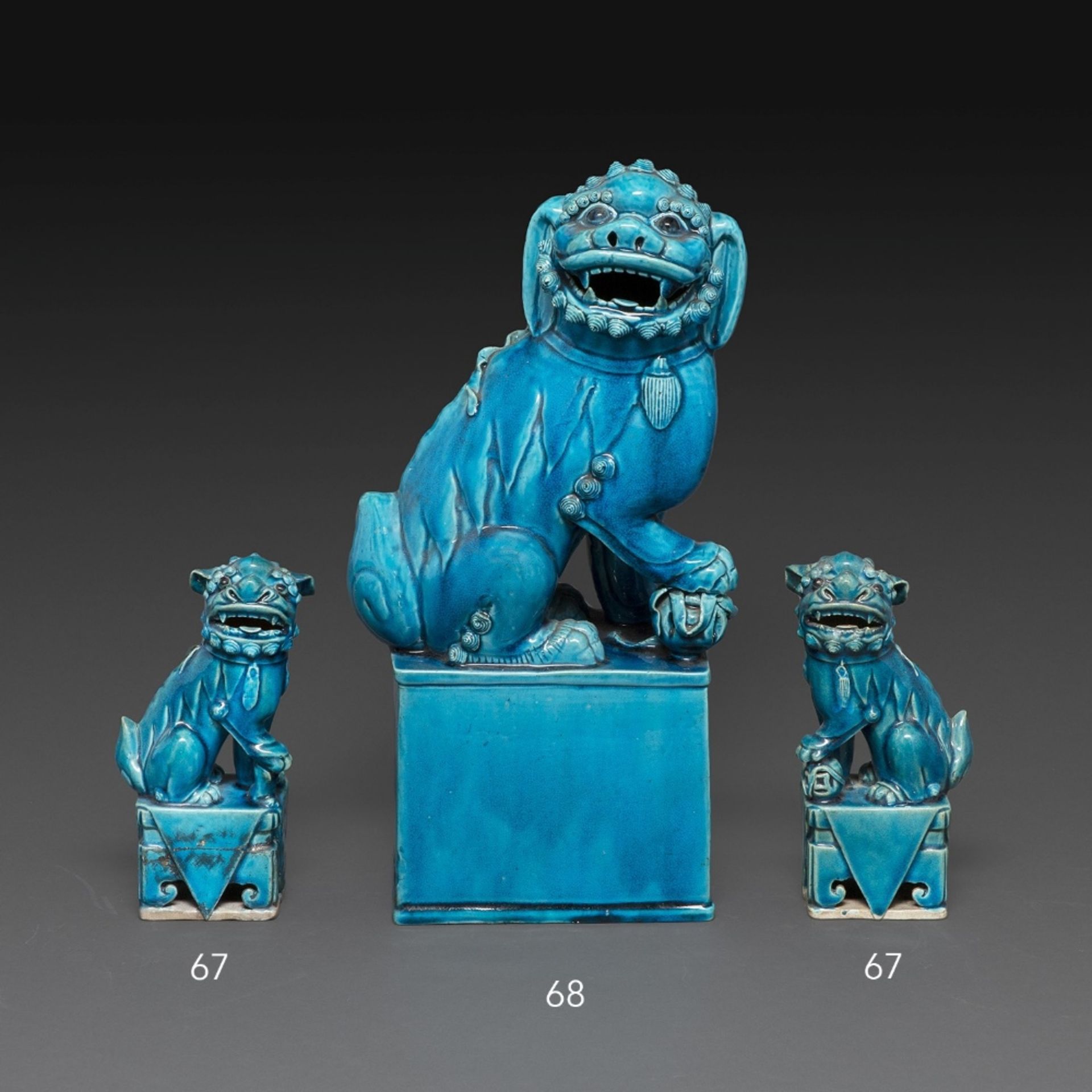 PAIRE DE LIONS BOUDDIQUES en biscuit émaillé bleu turquoise, représentés assis sur un socle ajouré