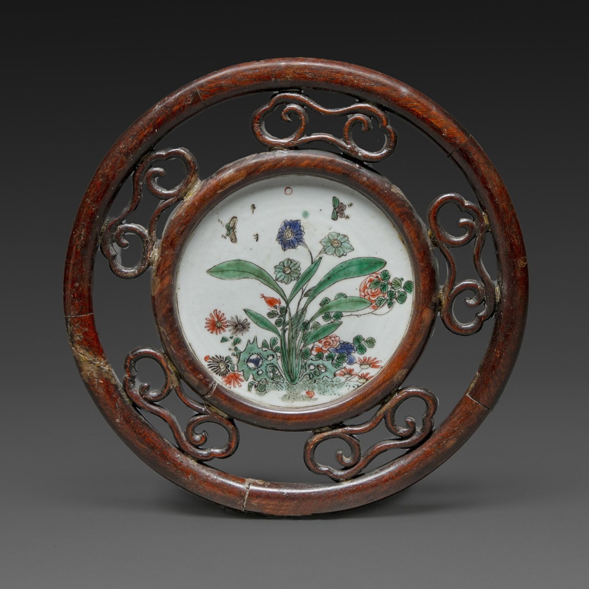 PLAQUE CIRCULAIRE en porcelaine et émaux polychromes de la famille verte, à décor de fleurs,