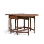 TABLE A VOLETS DE FORME OVALE EN NOYER MOULURÉ, XVIIe SIÈCLE Elle ouvre par un tiroir en ceinture.