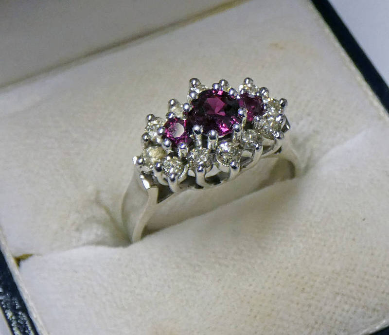 18CT GOLD RUBY & DIAMOND SET RING, THE 3 GRADUATED RUBIES IN A SURROUND OF APPROX 0.