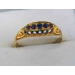 18CT GOLD 5-STONE GARNET SET RING IN A SCROLL MOUNT Condition Report: Ring size: R.