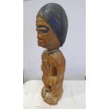 AFRICAN MALE STANDING FIGURE WITH SIMPLE COIFFURE HOLDING A VESSEL,