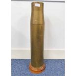 ARTILLERY SHELL STICK STAND ON A TURNED WOODEN BASE,