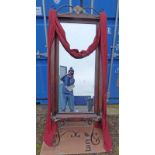 MAHOGANY FRAMED WALL MIRROR WITH CARVED DECORATION & RED DRAPE AND WROUGHT IRON STAND - OVERALL