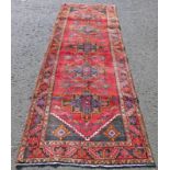 RED GROUND PERSIAN RUNNER WITH CROSS MEDALLION DESIGN 323 X 110CM Condition Report: