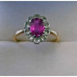 18CT GOLD RUBY AND DIAMOND CLUSTER RING, THE OVAL RUBY IN A SURROUND OF 10 DIAMONDS, VERY APPROX 0.