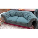 BUTTON BACKED 2 SEATER CHESTERFIELD SETTEE ON BUN FEET WITH GREEN FLORAL PATTERN .