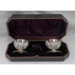 CASED PAIR OF VICTORIAN SILVER SALTS WITH BLUE GLASS LINERS,
