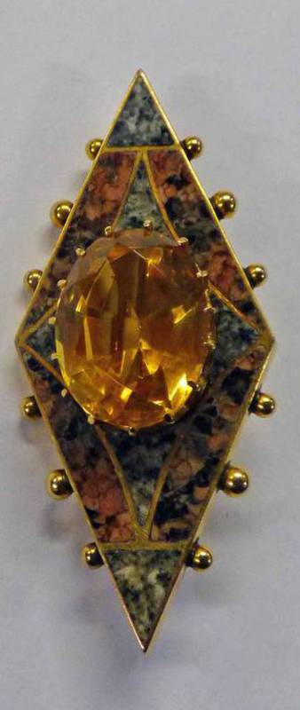 SCOTTISH CITRINE AND GRANITE BROOCH WITH CENTRAL CLAW SET OVAL CUT CITRINE SURROUNDED BY RED AND