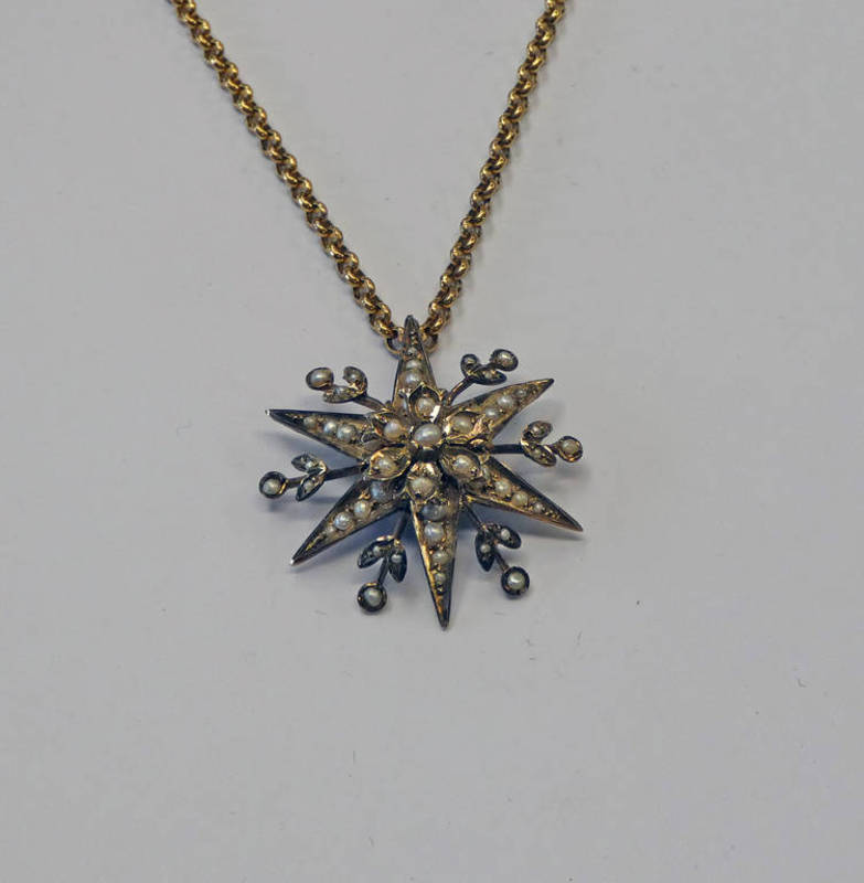 9CT GOLD PEARL SET STARBURST PENDANT ON A 9CT GOLD CHAIN - 15.