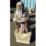 RECONSTITUTED STONE ORIENTAL GARDEN STATUE OF MAN WITH FISH ON PLINTH BASE,