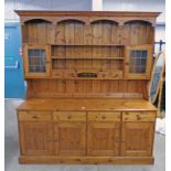 PINE DRESSER WITH 2 GLASS PANEL DOORS AND 2 DRAWERS OVER BASE OF 4 DRAWERS OVER 2 PANEL DOORS,