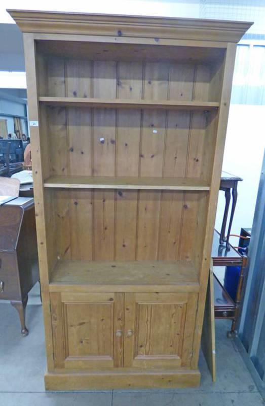 PINE BOOKCASE WITH SHELVES OVER 2 PANEL DOORS,