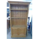 PINE BOOKCASE WITH SHELVES OVER 2 PANEL DOORS,