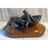 BRONZE FIGURE OF A FISHERMAN IN A DAMAGE SAILING BOAT ON A WOODEN PLINTH.