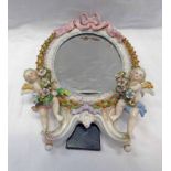 EARLY 20TH CENTURY FLORAL ENCRUSTED MIRROR DECORATED WITH CHERUBS & A PINK RIBBON - 30CM TALL