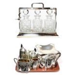 A Group of silver plate and pewter, including: an oblong tantalus with three cut-glass decanters and