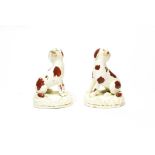 A pair of Staffordshire seated spaniels circa 1840, painted with red liver patches, 9cm high. No