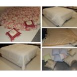 Assorted bedding and textiles comprising two cream bed spreads, red and white bed cover, matching