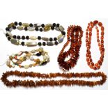 A chalcedony bead necklace, length 76cm; two irregular shaped amber bead necklaces; and two