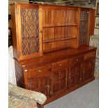 A modern oak dresser, the upper section with shelves and lead glazed doors, the lower section fitted