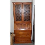 A modern oak bureau bookcase with leaded glass upper section, 84cm by 28cm by 185cm