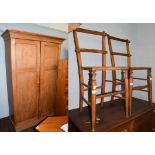 A pine double wardrobe, together with two cane seated bedroom chairs. Wardrobe 204.5cm by 134cm by