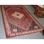 Kashgai rug, the raspberry lozenge field with central stepped medallion framed by spandrels and