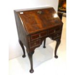 A Walnut and Crossbanded Small Bureau, in George I style, the fall enclosing a fitted interior of