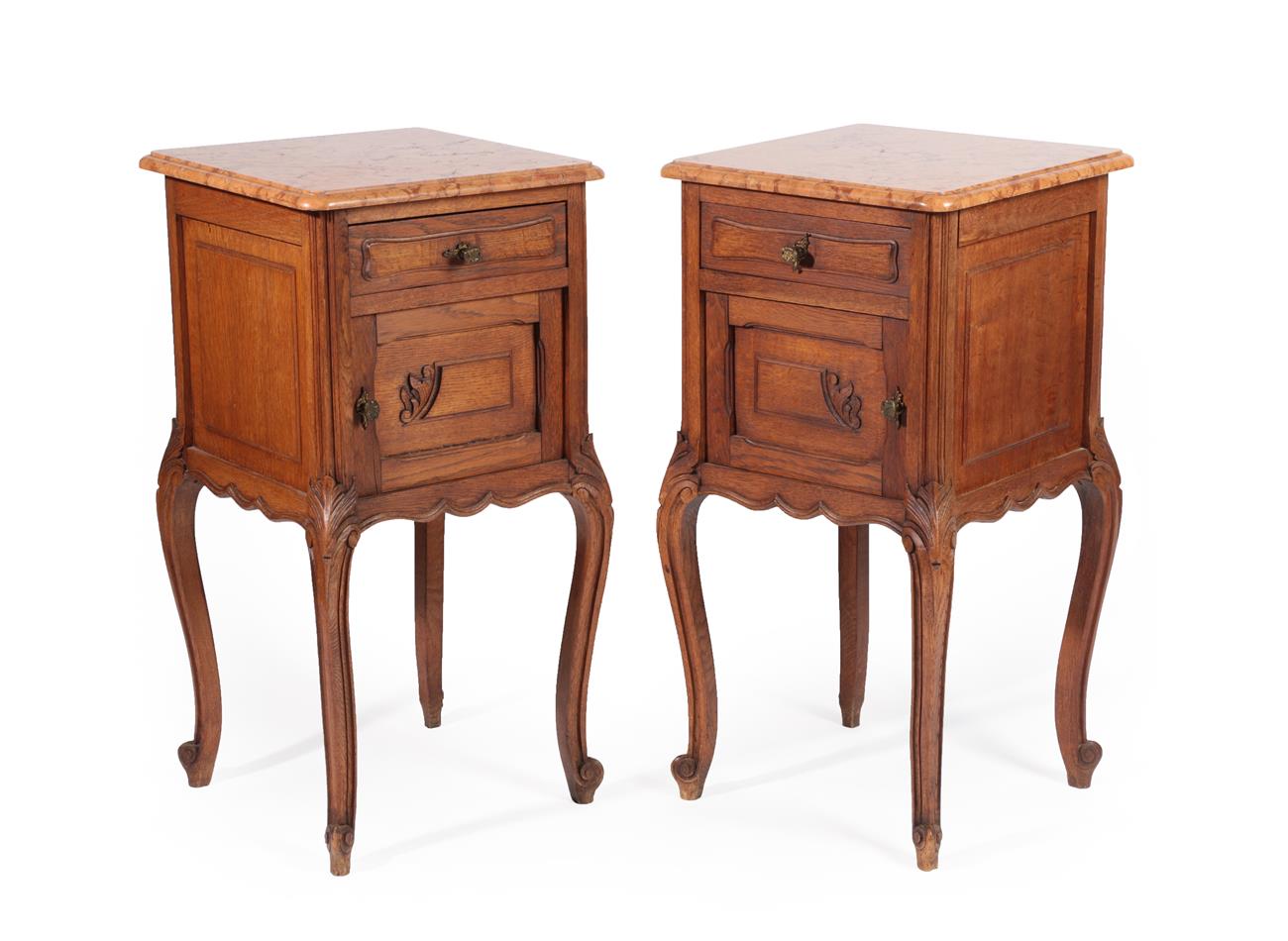 A Pair of French Oak Bedside Cupboards, with pink marble tops above a single drawer with cupboard