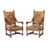 A Pair of Late 19th Century Carved Walnut Baroque Style Armchairs, upholstered in brass studded