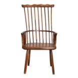 A Yewwood Stick-Back Armchair, the comb shaped top rail above curved armrests and a solid yewwood