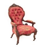 A Victorian Carved Walnut Open Armchair, circa 1870, covered in buttoned pink floral fabric, the