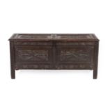 A 17th Century Joined Oak Chest, the hinged lid carved overall with scrolled and S shape motifs,