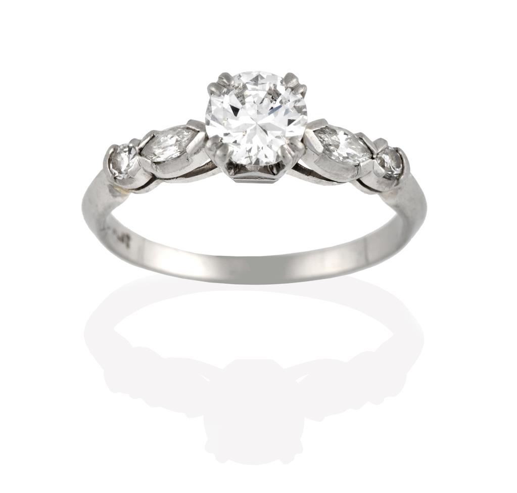 A Diamond Solitaire Ring, the round brilliant cut diamond in a white claw setting, to a marquise and