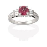 A Tourmaline and Diamond Ring, the round cut pink tourmaline flanked by trios of baguette cut