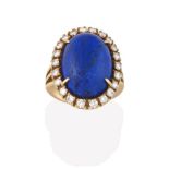 A Lapis Lazuli and Diamond Cluster Ring, the oval lapis lazuli cabochon within a border of round