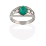 An Emerald and Diamond Ring, the cabochon emerald in a white collet setting, to shoulders inset with