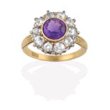 An Amethyst and Diamond Cluster Ring, the round cut amethyst in a yellow rubbed over setting, within