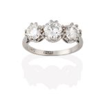 A Diamond Three Stone Ring, the graduated round brilliant cut diamonds in white claw settings, to