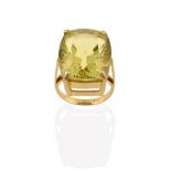 A Citrine Ring, the fancy oval cut citrine in a yellow four claw setting, to a tapered shoulder