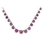 An Edwardian Amethyst Necklace, sixteen graduated round cut amethysts in yellow collet settings,