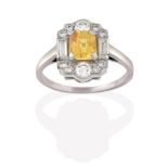 A Yellow Sapphire and Diamond Cluster Ring, the emerald-cut yellow sapphire within a border of