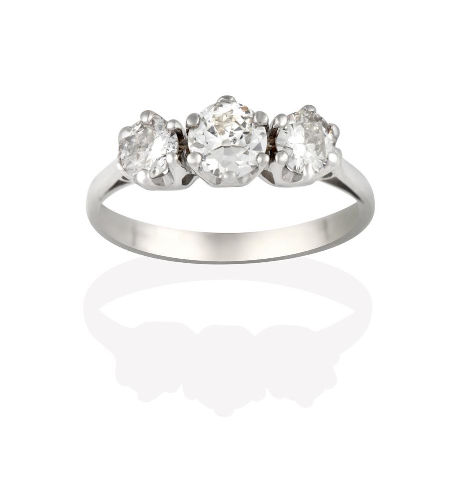 A Diamond Three Stone Ring, the round brilliant cut diamonds in white claw settings, to a tapered