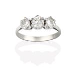 A Diamond Three Stone Ring, the round brilliant cut diamonds in white claw settings, to a tapered