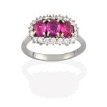 A Ruby and Diamond Cluster Ring, three oval cut rubies within a border of round brilliant cut