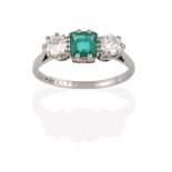 An Emerald and Diamond Three Stone Ring, the central step cut emerald flanked by round brilliant cut
